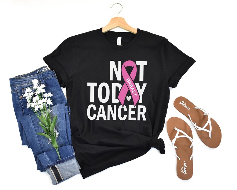 May include: Black t-shirt with the text "Not Today Cancer" and a pink ribbon with the word "Breast" on it.