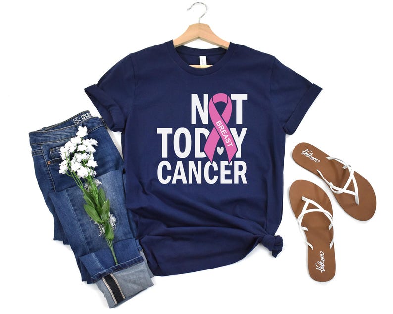 May include: A navy blue t-shirt with the text "NOT TODAY CANCER" and a pink ribbon with the word "BREAST" on it.