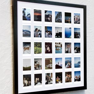 May include: A black framed photo collage featuring multiple small photographs. The photos are of various scenes, including landscapes, people, and objects. The collage is mounted on a white background.