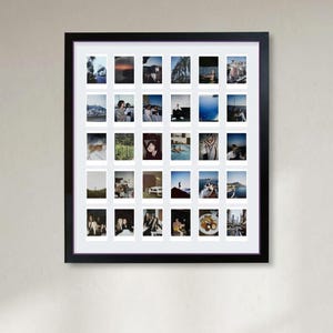 May include: A black rectangular frame containing a white mat with a grid of thirty small rectangular instant film photographs. The photos display various scenes including landscapes, people, food, and travel moments arranged in six rows of five.