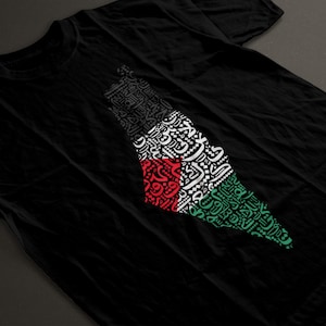 May include: Black t-shirt with a graphic of the outline of Palestine, created using Arabic calligraphy in white, red, and green.
