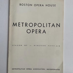 May include: A white programme for the Metropolitan Opera season of 1956 at the Boston Opera House. The programme states "Metropolitan Opera Association, Incorporated".