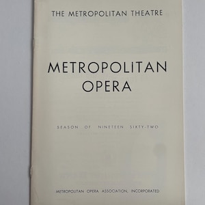 May include: A white program for the Metropolitan Opera season of 1962. The program features the text "The Metropolitan Theatre" and "Metropolitan Opera" in bold black font.