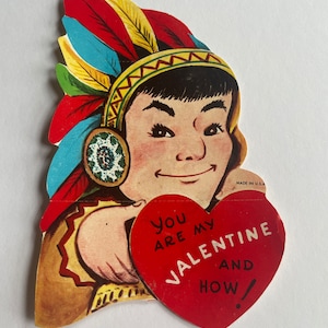 Può includere: Un biglietto di San Valentino vintage con un personaggio di cartone animato nativo americano che indossa un copricapo colorato e tiene un cuore rosso su cui è scritto "You are my Valentine and how!"