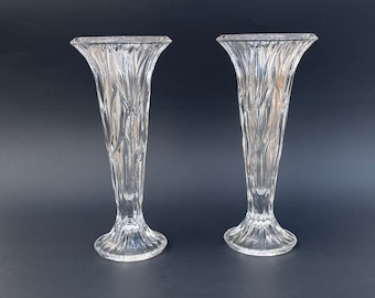 May include: Two clear glass bud vases with a textured, diamond-like pattern. The vases have a wide mouth and a narrow base.