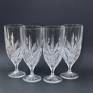 May include: Four clear glass goblets with a cut crystal design. The goblets have a wide bowl and a tall stem.