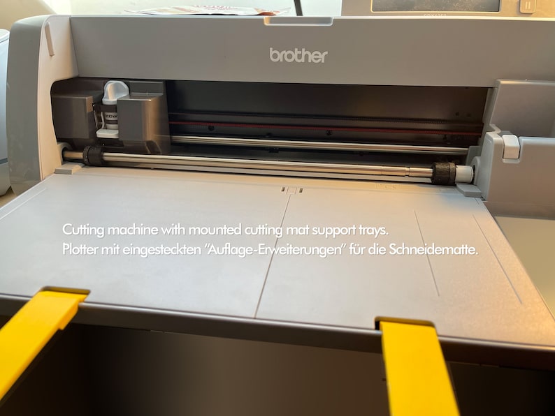 May include: A gray Brother cutting machine with yellow cutting mat support trays. The machine has a silver cutting blade and a white cartridge.