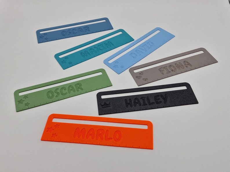 Pode incluir: Seis r&eacute;guas de pl&aacute;stico coloridas com nomes impressos nelas. Os nomes s&atilde;o Oscar, Marla, David, Fiona, Hailey e Oscar.