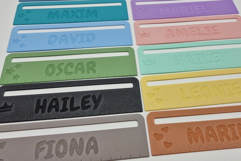 Pode incluir: Um conjunto de oito r&eacute;guas personalizadas com nomes diferentes, incluindo Maxim, David, Oscar, Hailey, Leonie, Mari, Amelie e Martel. Cada r&eacute;gua apresenta uma cor e um elemento de design diferentes, como estrelas, coroas ou cora&ccedil;&otilde;es.