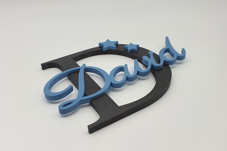 May include: A blue wooden name sign with the name "David" in a cursive font. The name is attached to a black wooden letter "D". Two blue stars are placed above the name.