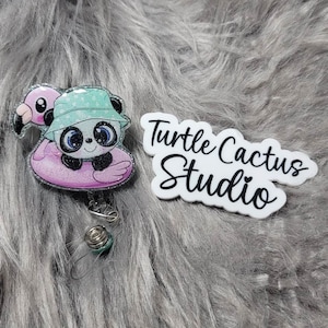 May include: A panda wearing a green hat and sunglasses floats on a pink flamingo pool float. The image includes the text "Turtle Cactus Studio".