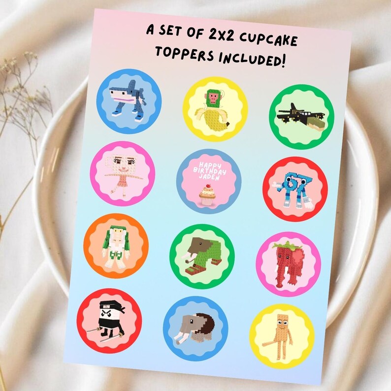 Op de afbeelding: Een vel met 2x2 cupcake toppers met kleurrijke, gepixelde ontwerpen. De toppers tonen verschillende karakters en objecten, waaronder een haai, aap, ninja en olifant. De tekst bovenaan luidt "A SET OF 2X2 CUPCAKE TOPPERS INCLUDED!"