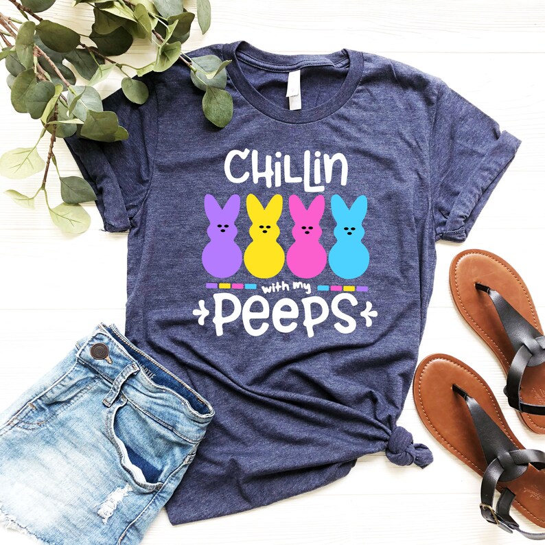 May include: A navy blue t-shirt with the text "Chillin with my peeps" and four colorful marshmallow Peeps.