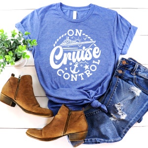 May include: A blue t-shirt with a white graphic of a cruise ship and the text "On Cruise Control" in a circle.