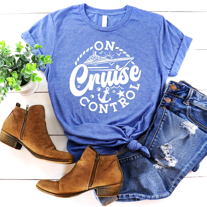 May include: A blue t-shirt with a white graphic of a cruise ship and the text "On Cruise Control" in a circle.