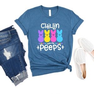 May include: A teal blue t-shirt with the text "Chillin with my peeps" and four colorful marshmallow peeps.