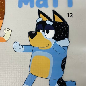 May include: A cartoon illustration of a blue dog character with black and white markings, striking a pose. The name "MATT" is written in blue letters above the dog. The number "12" appears twice in the image.