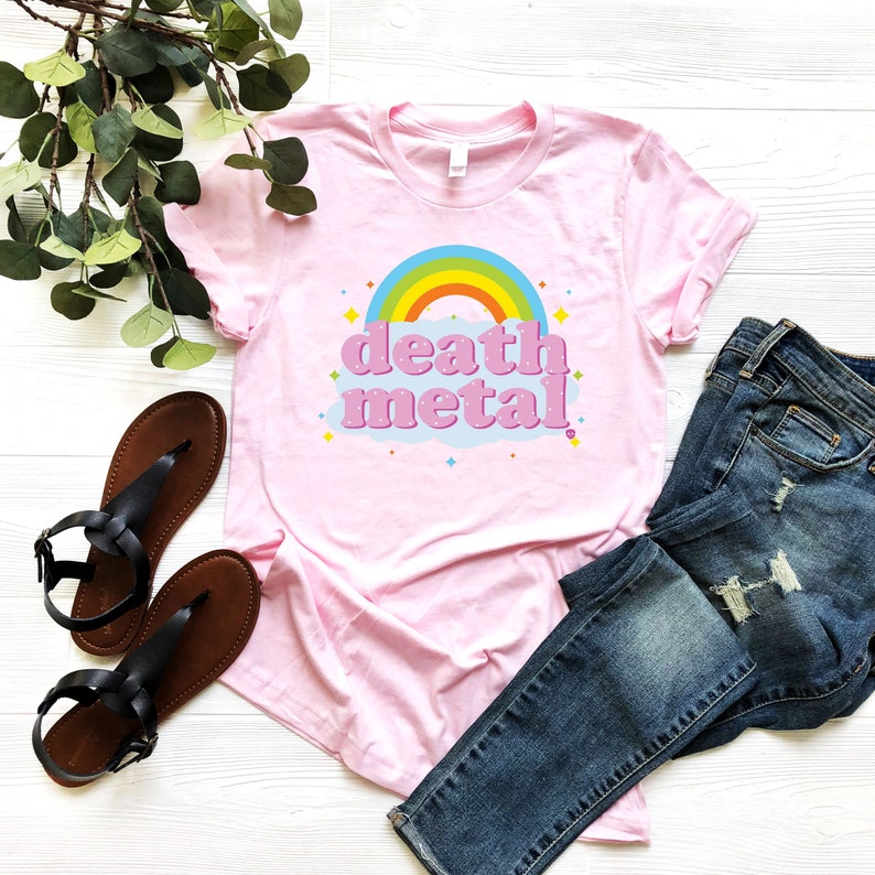 May include: Pink t-shirt with a rainbow and the text "death metal" in a retro font.