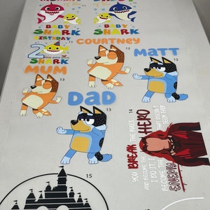 May include: A collection of colorful cartoon character decals, including sharks, dogs, and a superhero. Text includes "Baby Shark," "Birthday," and names. The decals are designed for various applications.