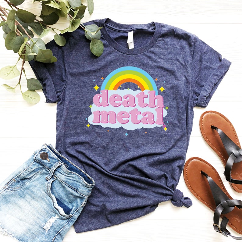 May include: A navy blue t-shirt with a rainbow and the text "death metal" in pink letters on a light blue cloud.
