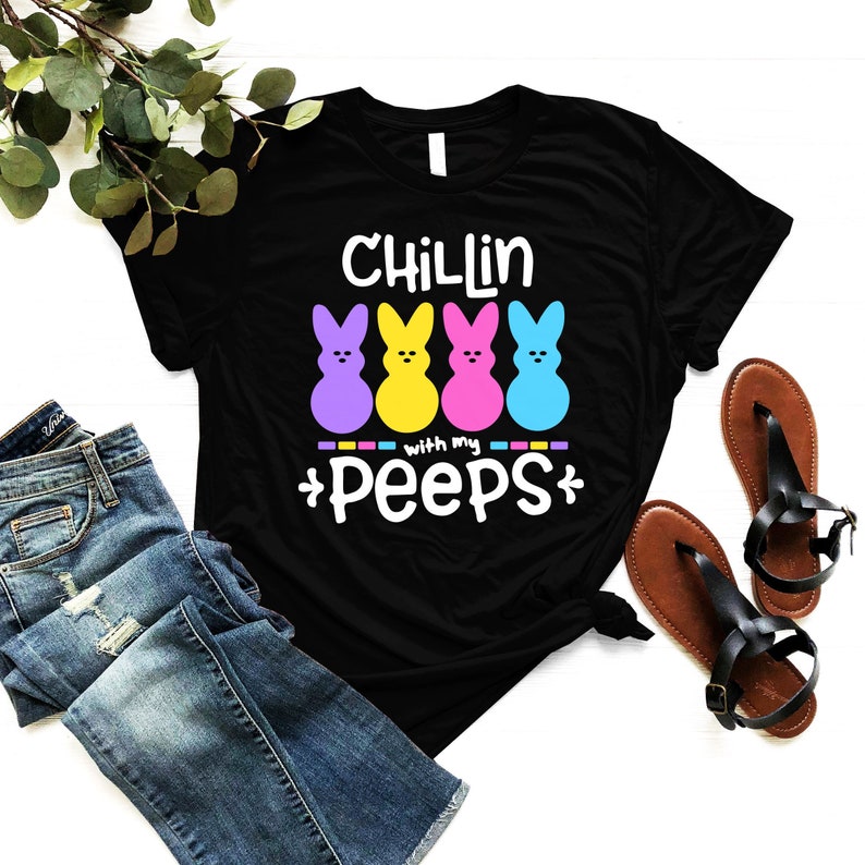 May include: Black t-shirt with the text "Chillin with my peeps" and four colorful marshmallow Peeps candy characters.