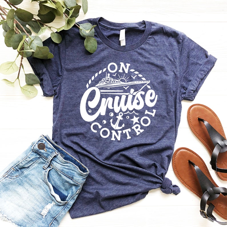 May include: A navy blue t-shirt with a white graphic design of a cruise ship and the text "On Cruise Control".