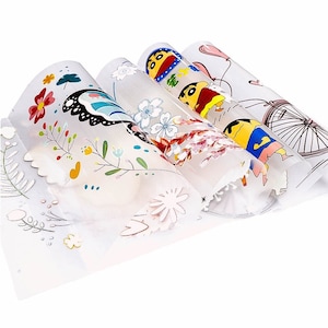 May include: Four rolled sheets of decorative paper with colorful illustrations. Designs include flowers, a butterfly, a cartoon character, and a bicycle. The paper is translucent with scalloped edges.