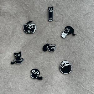 Broche en émail représentant un chat noir avec de jolis motifs
