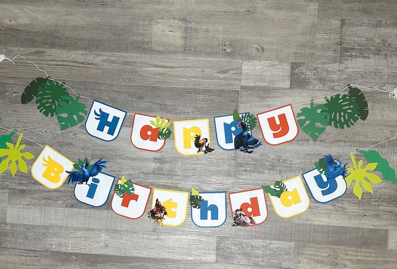 May include: A colorful "Happy Birthday" banner with jungle animal characters and green leaves. The letters are in different colors and each letter has a different animal character.