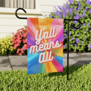 May include: A colorful garden flag with a rainbow background and the text "y'all means all" in white.
