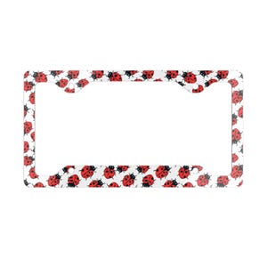 May include: White metal license plate frame with a pattern of red ladybugs on a white background.