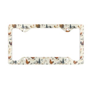 May include: White metal license plate frame with a pattern of brown and white chickens, barns, and trees on a cream background.