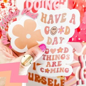 May include: A set of four mini stickers with a pink and peach color scheme. The stickers feature the phrases "Have a Good Day", "Good Things Are Coming", and a simple flower design.