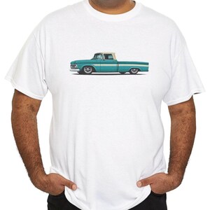 Puede incluir: Camiseta blanca con un gráfico de camioneta vintage turquesa y blanca. La ilustración muestra la camioneta de perfil, con cabina blanca y carrocería turquesa. La camiseta es de cuello redondo clásico.