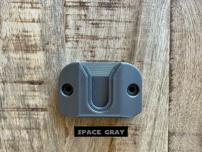 May include: A gray plastic wall mount with a U-shaped cutout. The text "SPACE GRAY" is printed below the mount.