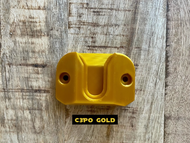 May include: A gold-colored plastic wall mount with two screw holes. The text "C3PO GOLD" is printed below the mount.