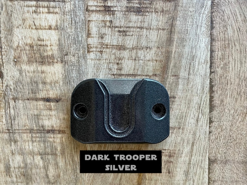 May include: A dark gray wall mount hook with a U-shaped opening. The hook is labeled "DARK TROOPER SILVER".