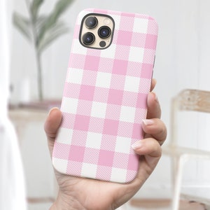 May include: A pink and white checkered phone case for an iPhone.