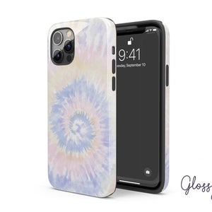 May include: A white phone case with a tie-dye pattern in shades of blue, pink, and yellow. The case is designed for an iPhone with a camera bump and a glossy finish.