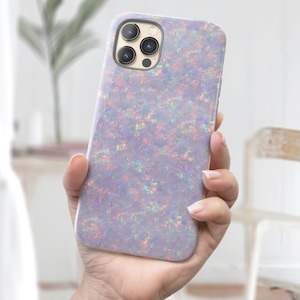 May include: A white iPhone case with a glittery iridescent opal design. The case has a camera cutout for a triple lens camera.