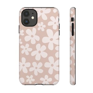 May include: A pink phone case with a white daisy pattern. The case has a black border and a cutout for the camera lens.