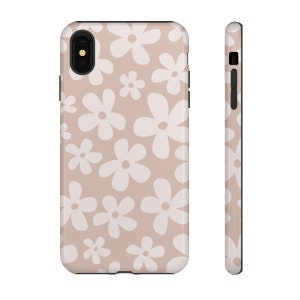 May include: A phone case with a pink background and a white daisy pattern.