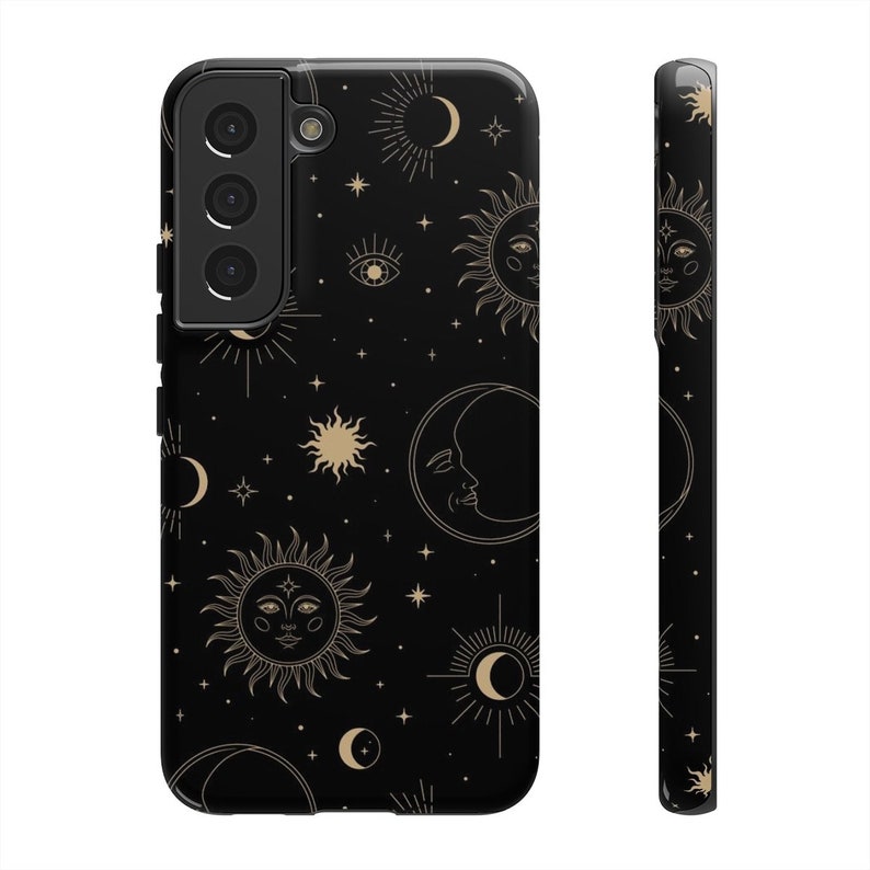 May include: A black phone case with a gold celestial pattern. The pattern includes suns, moons, stars, and eyes. The case has a cutout for the camera lens.
