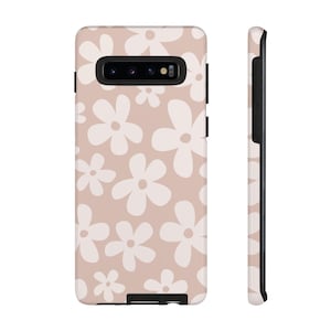 May include: A blush pink phone case with a white daisy pattern. The case is designed for a Samsung Galaxy S10.