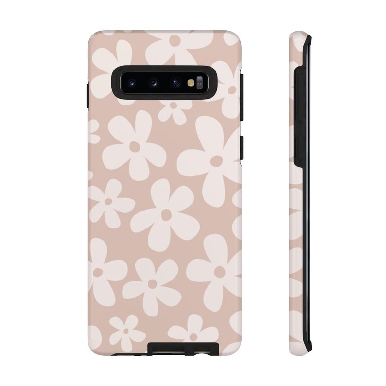 May include: A blush pink phone case with a white daisy pattern. The case is designed for a Samsung Galaxy S10.