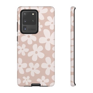 May include: A pink phone case with a white daisy pattern. The case has a black border and a camera cutout with the text "SPACE ZOOM 100X".