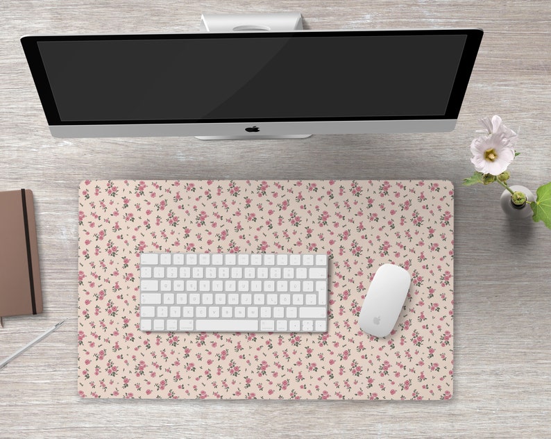 K&ouml;nnte beinhalten: Eine wei&szlig;e Schreibtischunterlage mit einem rosa Blumenmuster. Auf der Unterlage liegen eine wei&szlig;e Tastatur und eine wei&szlig;e Maus.