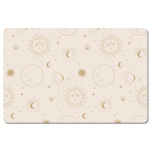 May include: A beige background with a repeating pattern of gold suns, moons, and stars. The suns and moons have faces and are surrounded by rays. The stars are small and scattered throughout the pattern.