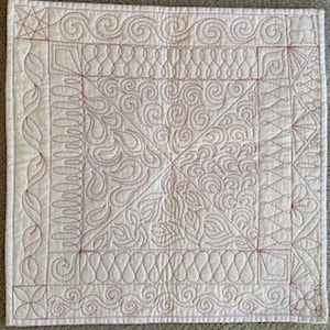 May include: A white quilted fabric with a variety of red stitching patterns, including swirls, waves, and geometric shapes.
