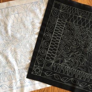 May include: Two pieces of fabric with a white background and black background. Both fabrics have a pattern of swirls and lines in a light blue color on the white fabric and a silver color on the black fabric.